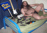 Fat hairy man in a speedo with guns and Guitar Hero controllers