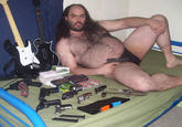 Fat hairy man in a speedo with guns and Guitar Hero controllers