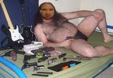Fat hairy man in a speedo with guns and Guitar Hero controllers